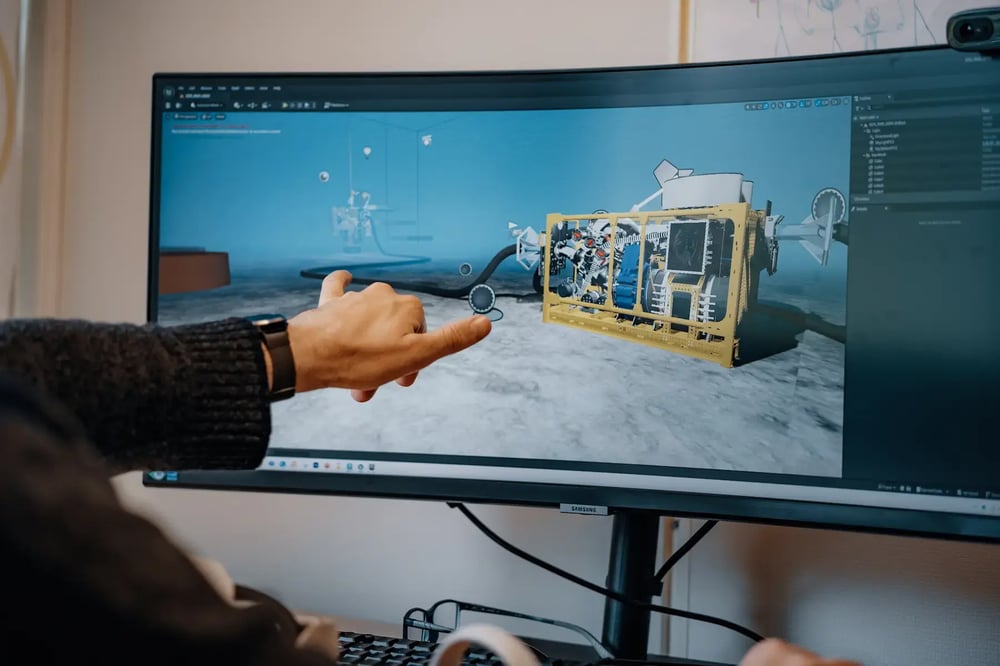Engineer reviewing 3D model of subsea equipment on a computer screen. Engineer reviewing 3D model of subsea equipment on a computer screen.