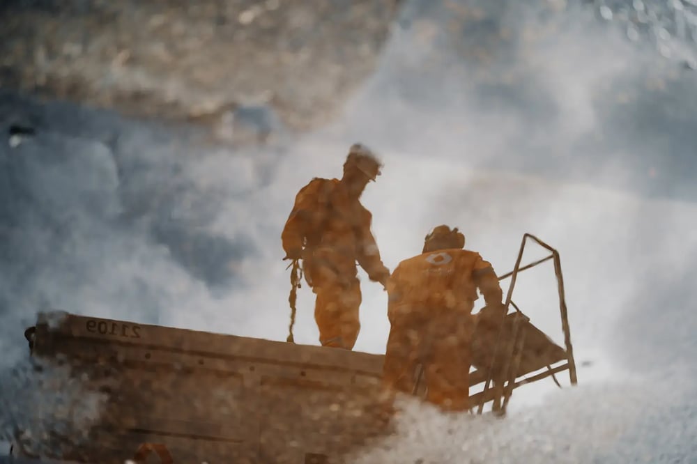 Reflection of two offshore workers in safety gear standing on platform equipment. Reflection of two offshore workers in safety gear standing on platform equipment.