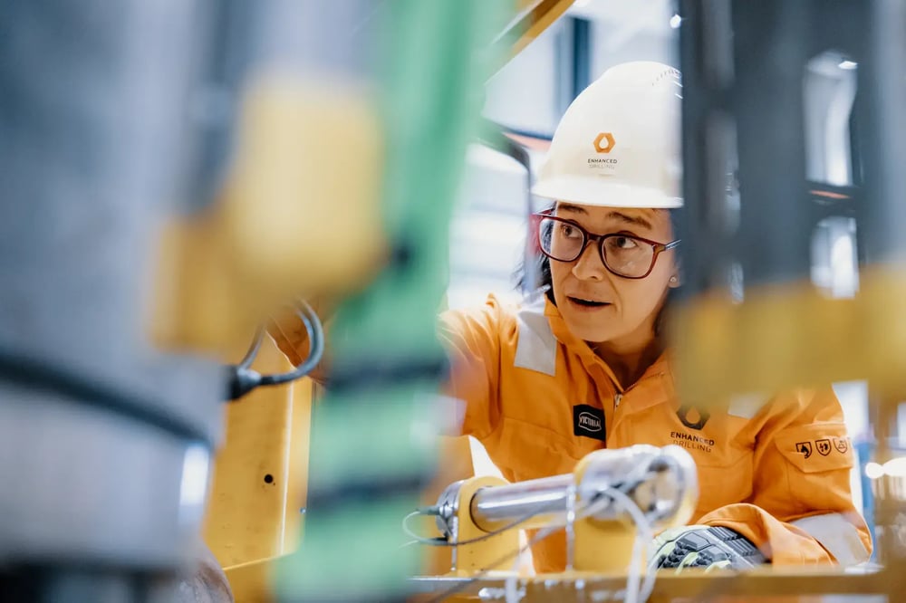 Enhanced Drilling engineer in safety gear inspecting equipment inside the workshop. Enhanced Drilling engineer in safety gear inspecting equipment inside the workshop.